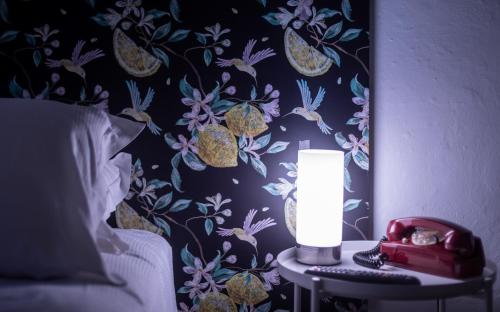 a bedroom with a bed with a lamp and a telephone at Hotel Casa Camilla in Verbania