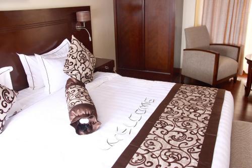 a bed in a hotel room with a large white bed at The White Rhino Hotel in Nyeri