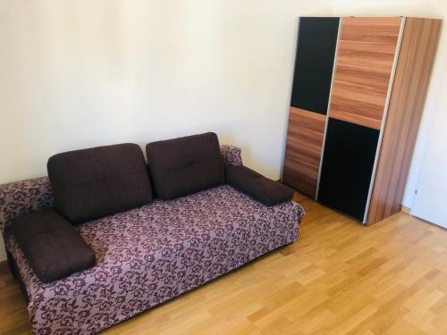 ein Sofa in einem Zimmer mit Holzboden in der Unterkunft Homestay Zürich HB Room in Zürich