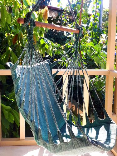 a hammock hanging from a fence in a garden at Pousada do Cacau in Arraial d'Ajuda