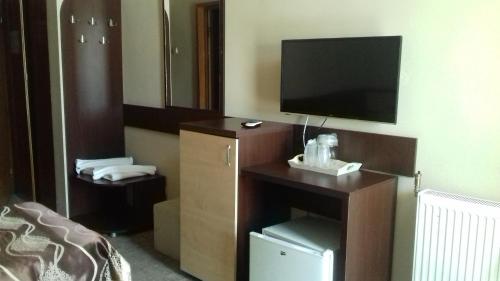 a hotel room with a tv and a desk with a bed at Hotel Valahia in Târgovişte
