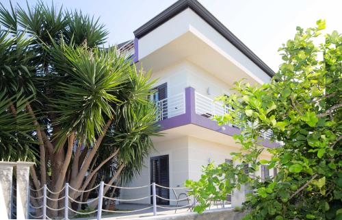 a house with a palm tree in front of it at Selenite in Capo dʼOrlando