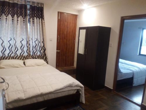 a small bedroom with a bed and a mirror at The Meadows in Kodaikānāl