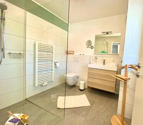 een badkamer met een glazen douche en een toilet bij FeWo Königsseer Ache in Berchtesgaden