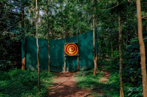 a fence with a painting on it in a forest at The Blossom Resort - Chikmagalur in Chikmagalūr