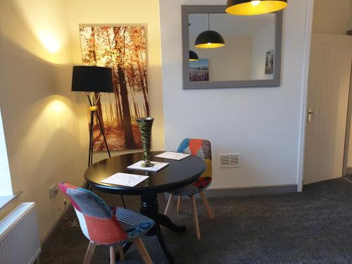 a room with a table with chairs and a mirror at The Old Inn at Plover Cottage Lindley in Huddersfield