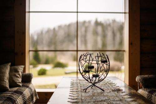 a vase sitting on a table in front of a window at Nuustaku Guesthouse in Otepää