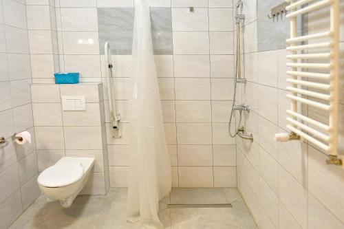a white bathroom with a toilet and a shower at Dom św. Józefa in Szczecin