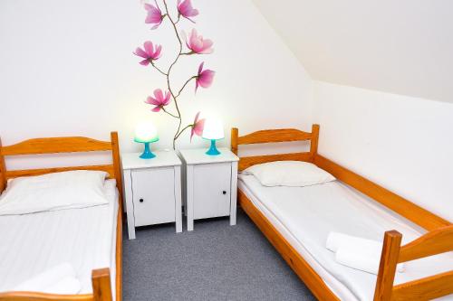 two beds in a room with two lamps on tables at Dom św. Józefa in Szczecin