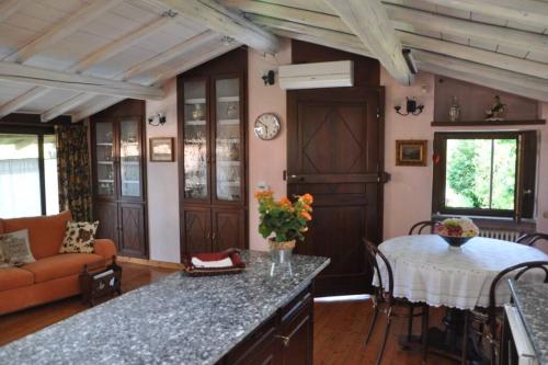 eine Küche und ein Wohnzimmer mit einem Sofa und einem Tisch in der Unterkunft la casa rossa nel bosco in Cantù