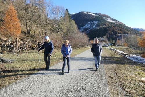 three people are walking down a gravel road at Haus Pleterski in Obervellach