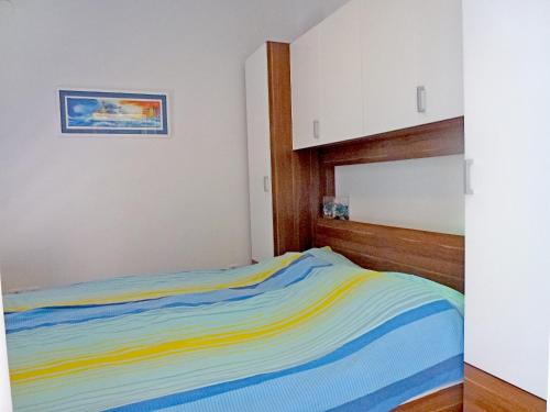 1 dormitorio con 1 cama de rayas de colores en Apartment Franc, en Njivice