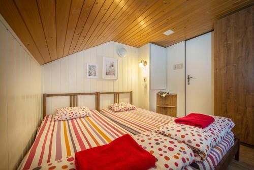 a bedroom with two twin beds with red sheets at Chata Borik in Svit