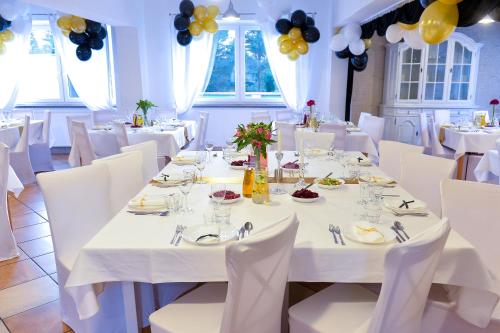 a dining room with white tables and chairs and balloons at Dom św. Józefa in Szczecin