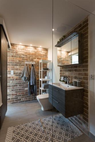 a bathroom with a sink and a brick wall at LEA Barn in Żagań