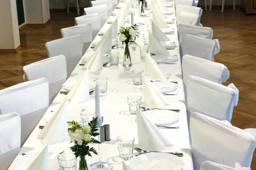a long table with white tables and white chairs at Dom św. Józefa in Szczecin