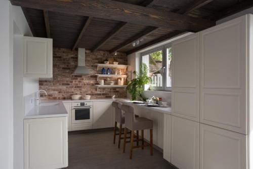 a kitchen with white cabinets and a brick wall at LEA Barn in Żagań