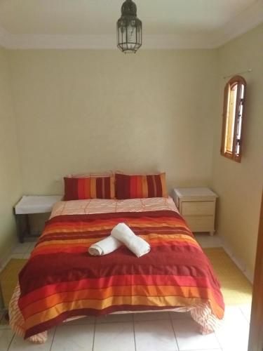 a bedroom with a bed with two towels on it at Riad Lalla Zahra in Marrakesh