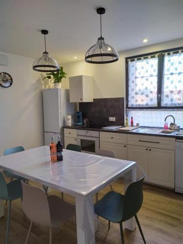 uma cozinha com uma mesa branca e cadeiras em L'Atelier de Robert em Carcassonne