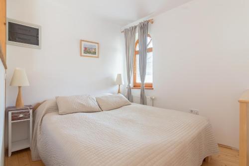 Habitación blanca con cama y ventana en Apartments Valant en Bled