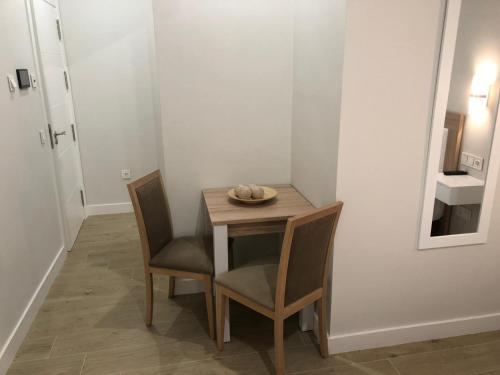 una mesa pequeña y sillas en una habitación en Pinar Malaga Rooms, en Málaga