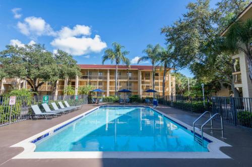 una piscina di fronte a un edificio con un resort di La Quinta East Deerfield Beach - Boca Raton a Deerfield Beach