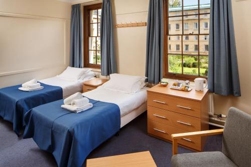 ケンブリッジにあるクライスツ カレッジ ケンブリッジのベッド2台と窓が備わるホテルルームです。