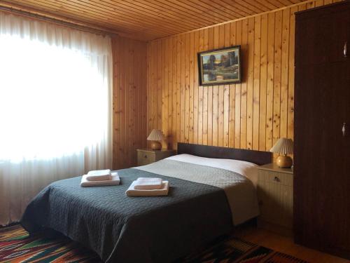 a bedroom with a bed with two towels on it at Котедж на Довбуша in Yaremche