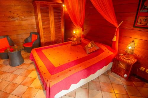 a bedroom with a bed in a wooden room at Baobab et Palmiers in Étang-Salé