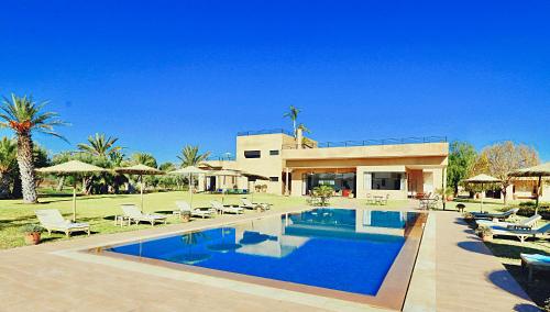 a house with a swimming pool in front of a house at Marrakech Retreat By La Siredrah in Marrakesh