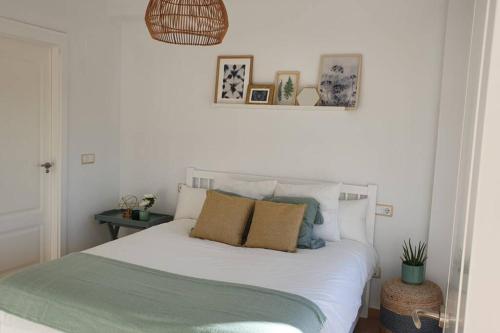 a bedroom with a white bed with pillows on it at Dúplex Águeda Altaona Golf in Murcia