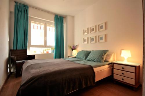 サンタ・ポラにあるApartment Sol de Santa Polaのベッドルーム1室(緑のカーテンと窓付きのベッド1台付)