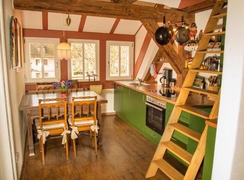 a kitchen with green cabinets and a table and chairs at RefuKium Altstadtscheune in Weißenburg in Bayern