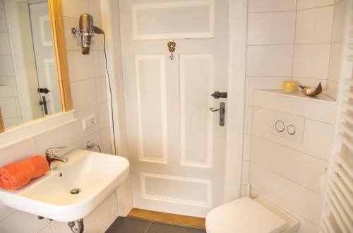 a white bathroom with a sink and a toilet at RefuKium Altstadtscheune in Weißenburg in Bayern