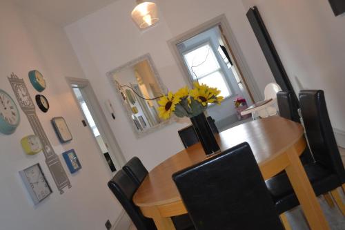 a dining room table with a vase of flowers on it at PENTHOUSE in Shanklin