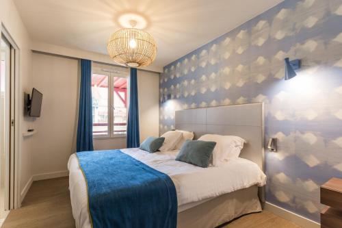 - une chambre dotée d'un grand lit avec un mur bleu dans l'établissement Résidence Pierre & Vacances Premium Presqu'Ile de la Touques, à Deauville