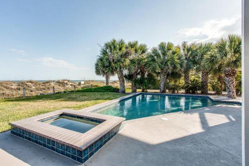 a swimming pool in a yard with palm trees at 101 Dune Lane in Hilton Head Island