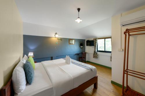 a bedroom with a bed with a blue wall at 88 Backpackers Hua Hin in Hua Hin