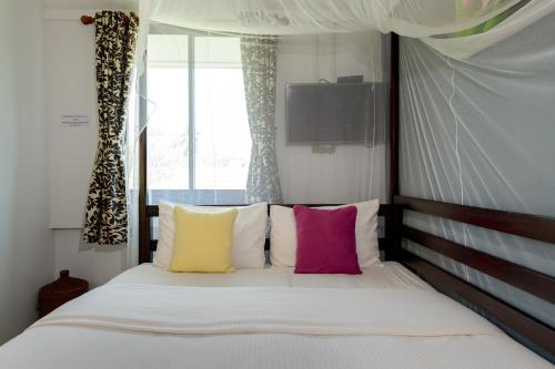 a bedroom with a large bed with colorful pillows at 88 Backpackers Hua Hin in Hua Hin