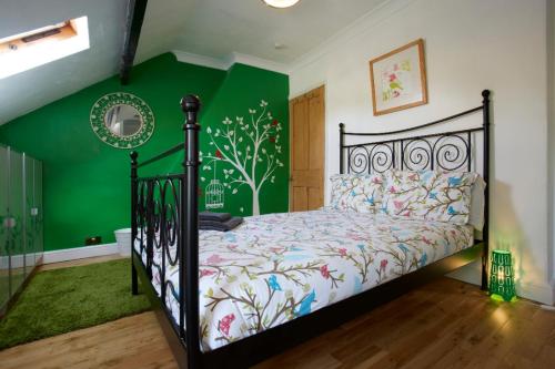 a bedroom with a bed with a green wall at Central Harrogate Townhouse - HIC Bottom of road! in Harrogate