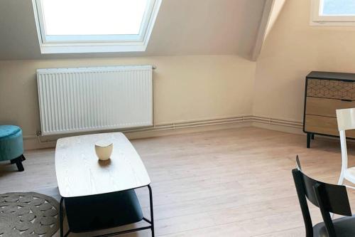 un salon avec une table et des chaises blanches dans l'établissement Caudry : Appartement spacieux plein centre, à Caudry