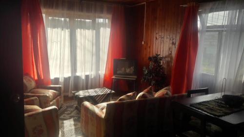 a living room with red curtains and a couch at Cabaña Punta Diamante in Castro