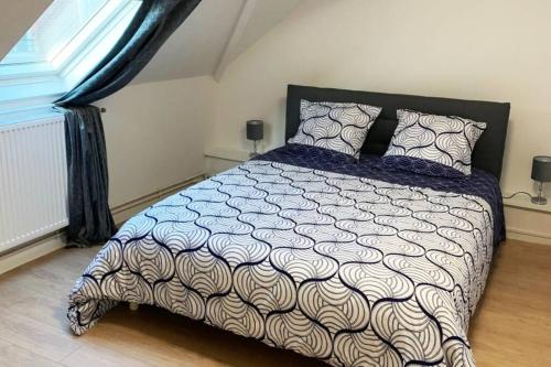 Un dormitorio con una cama grande y una ventana en Caudry : Appartement spacieux plein centre, en Caudry