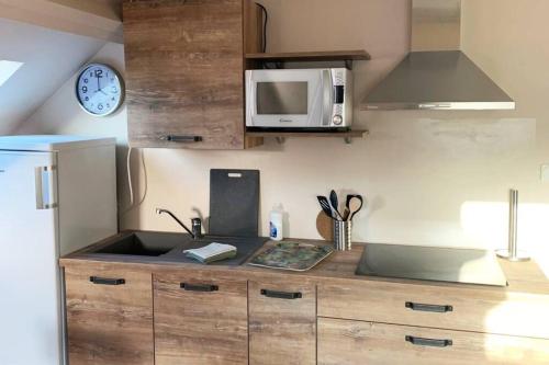 une cuisine avec un évier et un micro-ondes dans l'établissement Caudry : Appartement spacieux plein centre, à Caudry