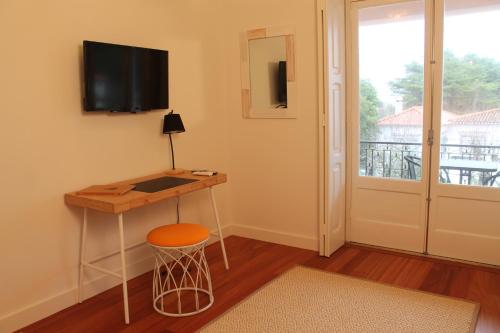 a room with a desk and a television on a wall at Villa Aedan Sintra in Sintra
