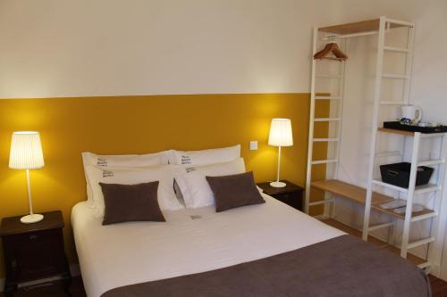 a bedroom with a white bed with two lamps at Villa Aedan Sintra in Sintra