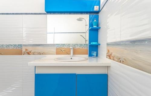 a bathroom with a sink with a beach scene on the wall at Ô Coeur Des Tropiques in Capesterre-Belle-Eau