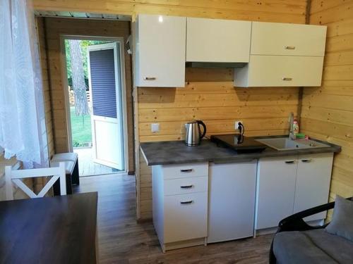 a kitchen with white cabinets and a counter top at Domek SERCE KRYNICY in Krynica Morska