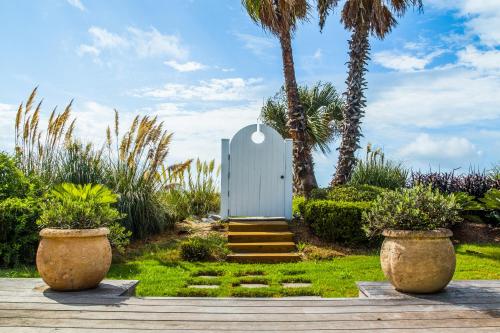 a garden with palm trees and a white door at 9 Dune Lane in Hilton Head Island