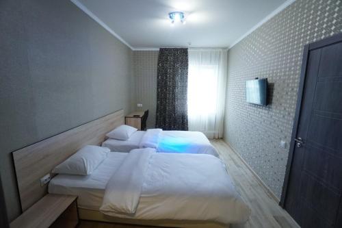 a bedroom with two beds and a window at HOTEL CITY M in Saratov